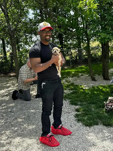 A man holding a small puppy outdoors